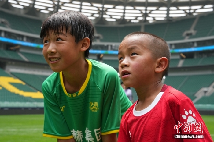 圖為北京國安小球員陳小北和7歲的俄金仁增在一起觀看場內(nèi)播放的紀(jì)錄片。<a target='_blank' href='/' _fcksavedurl='/'><p  align=