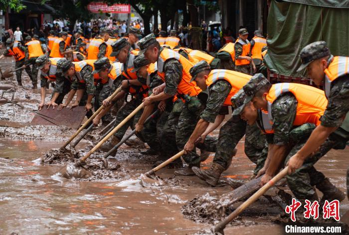 7月4日，萬州區(qū)五橋街道，武警官兵清理街道上的淤泥。　冉孟軍 攝