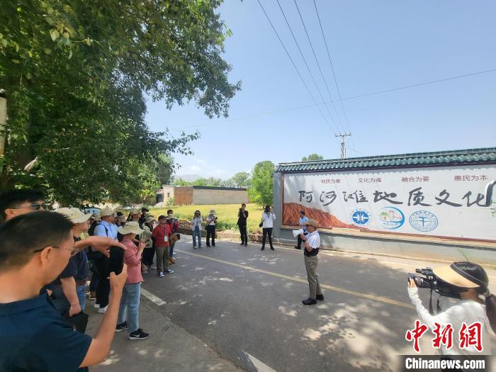 圖為中國地質(zhì)大學(xué)(北京)教授張緒教介紹村落情況。　胡友軍 攝