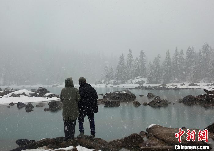 游客欣賞雪中然烏湖。　冉文娟 攝