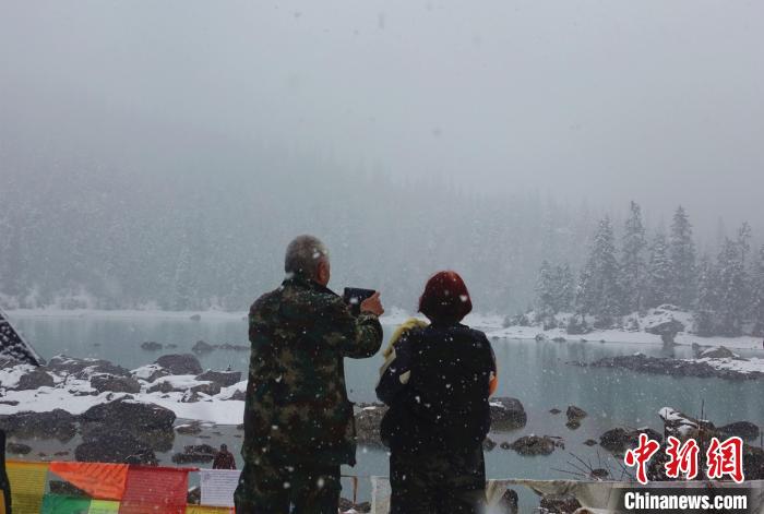 游客欣賞雪中然烏湖。　冉文娟 攝