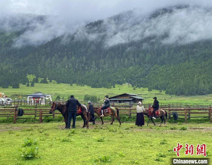 6月10日，游客在魯朗小鎮高山牧場(chǎng)景區體驗騎馬。　冉文娟 攝