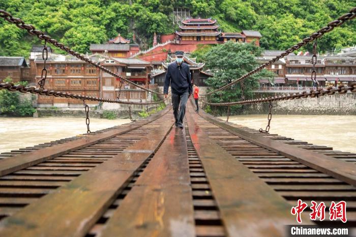 雨中游客行走在瀘定橋上。　劉忠俊 攝