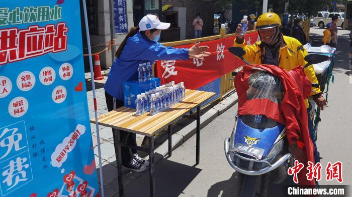 圖為近日，西藏自治區(qū)青年志愿者協(xié)會志愿者在拉薩街頭向快遞員送水。西藏自治區(qū)青年志愿者協(xié)會 供圖