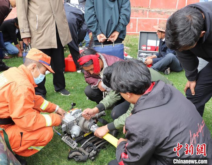 圖為森林消防員為護(hù)林員講解滅火裝備的使用方法。　昌都市森林消防支隊(duì) 供圖